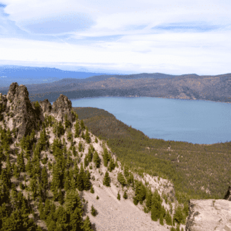 Mountainous landscape overlooking a blue lake surrounded by green forests.